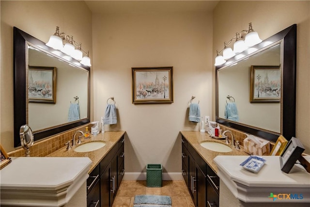 bathroom featuring tile patterned flooring, decorative backsplash, vanity, and baseboards