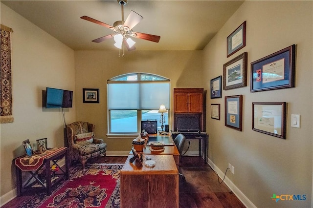 office area with dark wood-type flooring, baseboards, and a ceiling fan