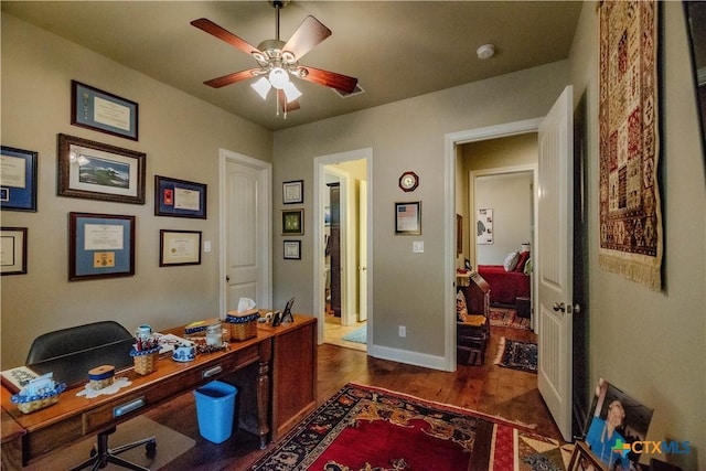 office space featuring dark wood-style floors, baseboards, and a ceiling fan