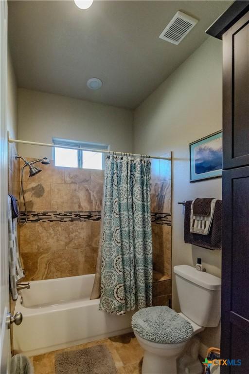 full bath featuring shower / tub combo, visible vents, and toilet