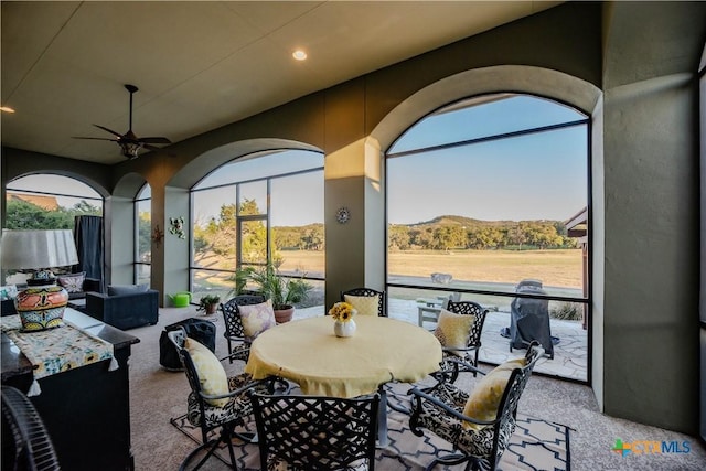 carpeted dining space with ceiling fan, a mountain view, and recessed lighting