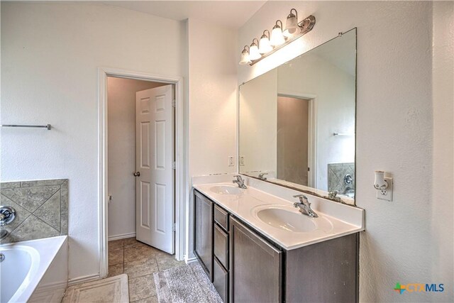 9505 Shimla Dr, Killeen, TX 76542 - bathroom featuring a garden tub, double vanity, and baseboards