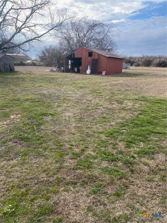 view of yard with a rural view and an outdoor structure