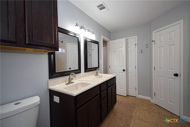 bathroom featuring toilet, vanity, and tile patterned floors