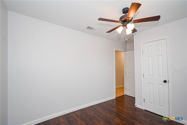 empty room with ceiling fan and dark wood-type flooring