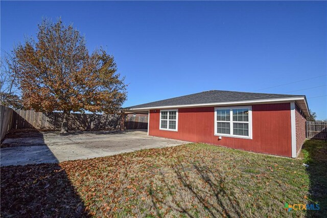 back of house with a patio and a lawn