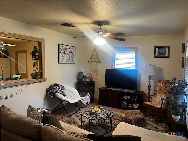 living room featuring a textured ceiling and ceiling fan