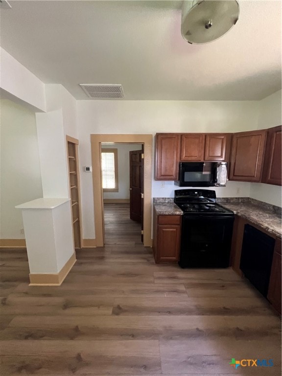 kitchen featuring dark wood-type flooring and black appliances