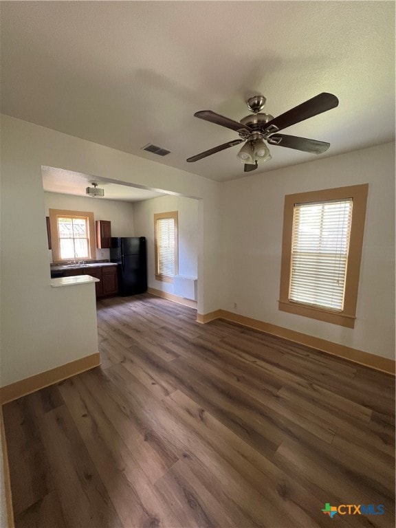 unfurnished living room with hardwood / wood-style floors and ceiling fan