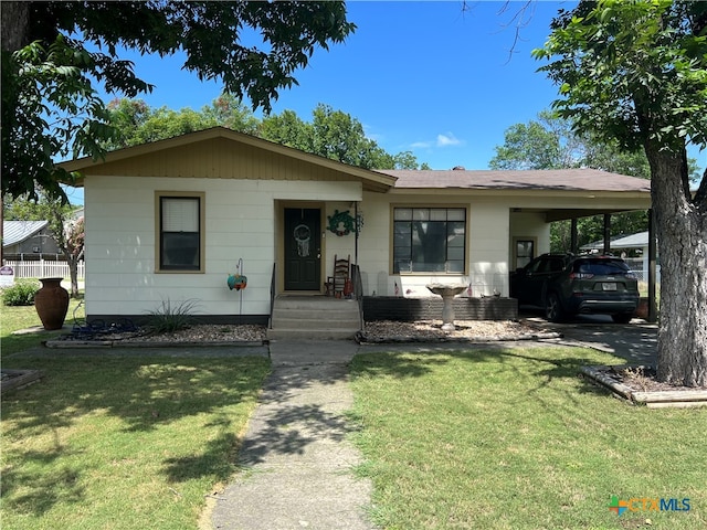 view of front facade featuring a front lawn and a carport