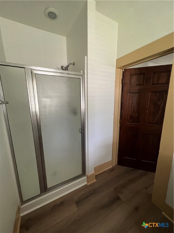 bathroom featuring hardwood / wood-style flooring and a shower with door