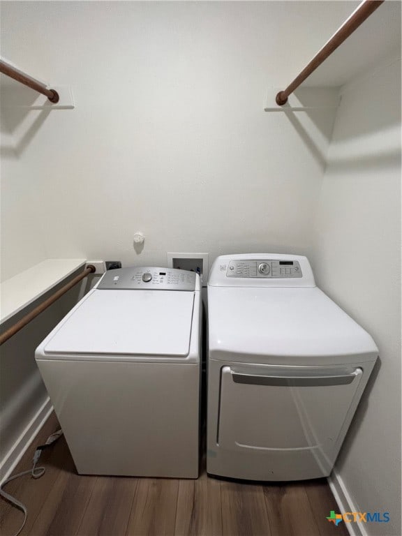 laundry room featuring washing machine and clothes dryer and dark hardwood / wood-style floors