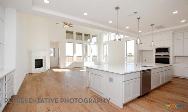 kitchen with a wealth of natural light, light wood-style flooring, appliances with stainless steel finishes, and a sink