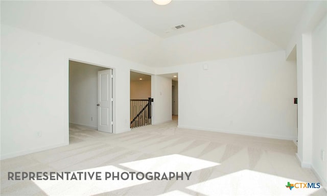 carpeted spare room featuring visible vents and baseboards