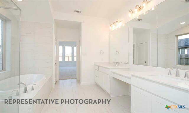 full bath featuring visible vents, double vanity, a bath, marble finish floor, and a sink