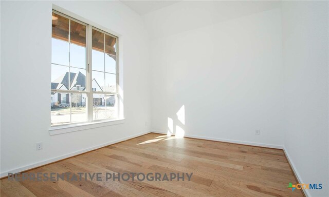 unfurnished room featuring baseboards and wood finished floors