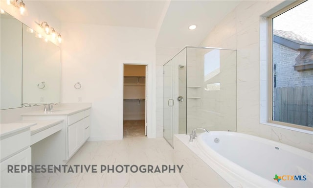 bathroom with a spacious closet, a shower stall, a bath, marble finish floor, and vanity