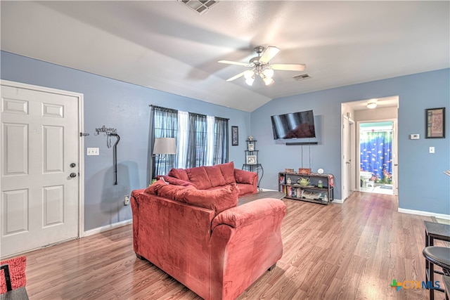 living room with ceiling fan, light hardwood / wood-style floors, a wealth of natural light, and vaulted ceiling