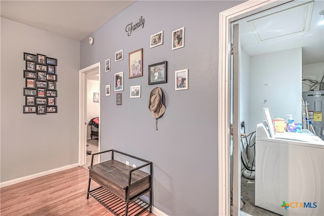 hallway featuring washer / clothes dryer, water heater, and hardwood / wood-style floors