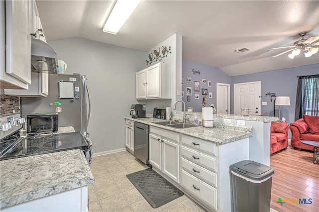 kitchen featuring white cabinets, vaulted ceiling, stainless steel dishwasher, and sink