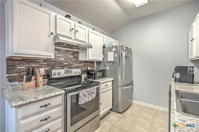 kitchen featuring white cabinetry, stainless steel appliances, tasteful backsplash, light stone counters, and lofted ceiling