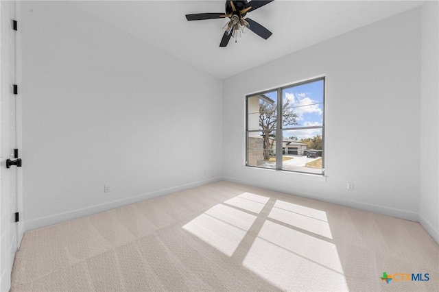 empty room with a ceiling fan, carpet, lofted ceiling, and baseboards