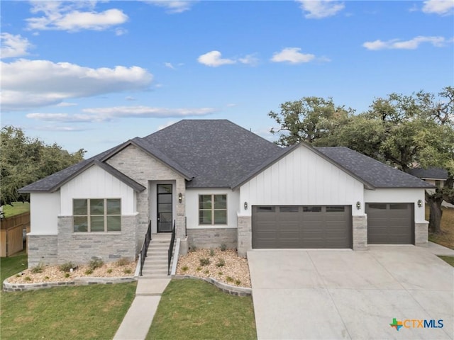 modern inspired farmhouse featuring roof with shingles, concrete driveway, an attached garage, fence, and a front lawn