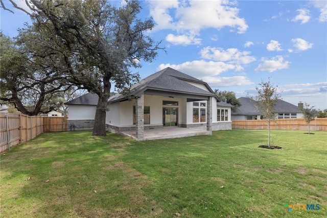 rear view of house featuring a patio, a yard, a fenced backyard, and stucco siding