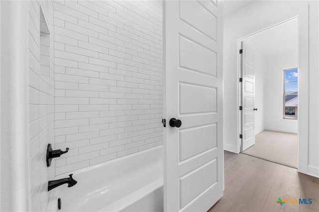 bathroom featuring shower / bath combination and wood finished floors