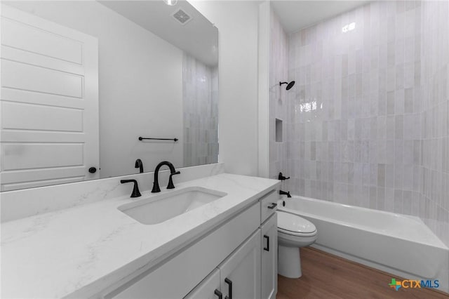 full bath with shower / bathtub combination, toilet, wood finished floors, vanity, and visible vents