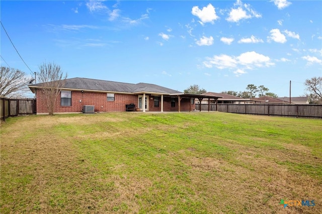 back of house with a lawn, central AC unit, a patio area, brick siding, and a fenced backyard