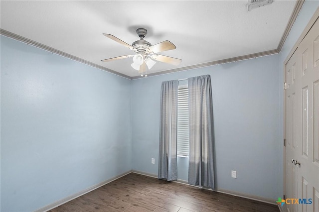 unfurnished room with crown molding, baseboards, a ceiling fan, and wood finished floors