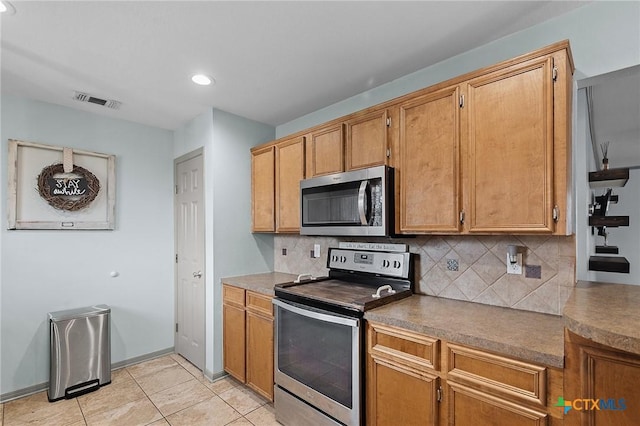 kitchen with appliances with stainless steel finishes, recessed lighting, decorative backsplash, light tile patterned floors, and visible vents