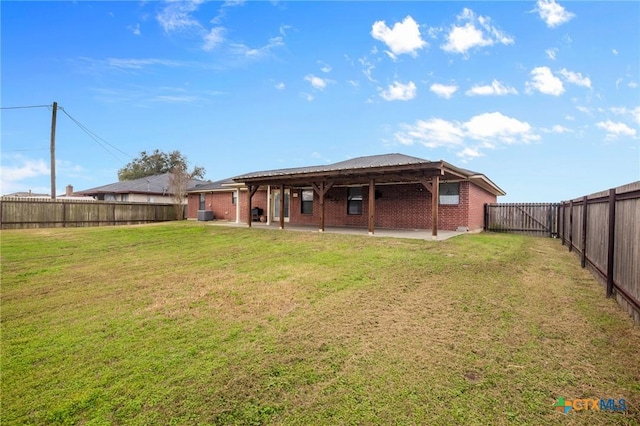 back of house featuring a patio, a fenced backyard, a yard, and brick siding