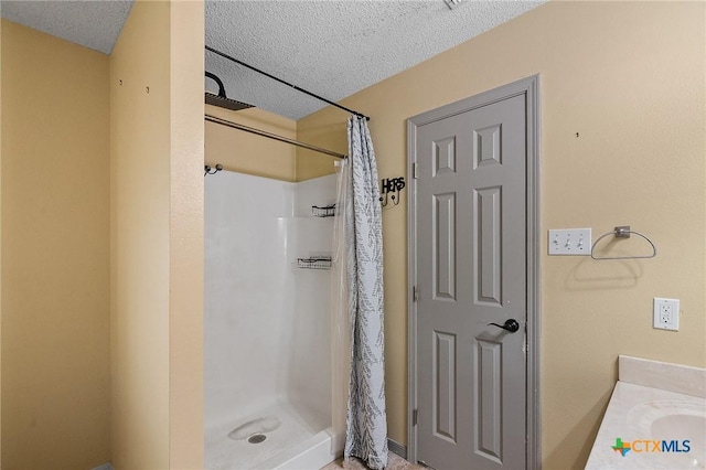 full bath with a shower stall and a textured ceiling