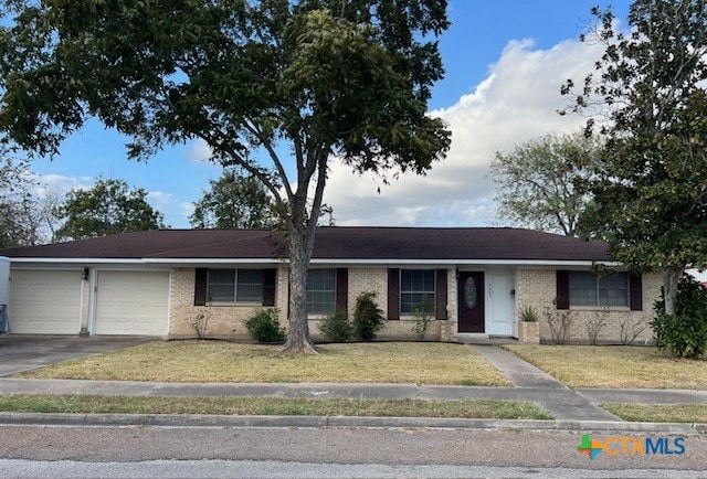 ranch-style home with a garage and a front lawn