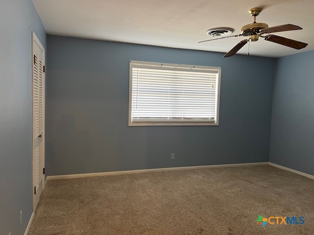 unfurnished room with ceiling fan and carpet flooring