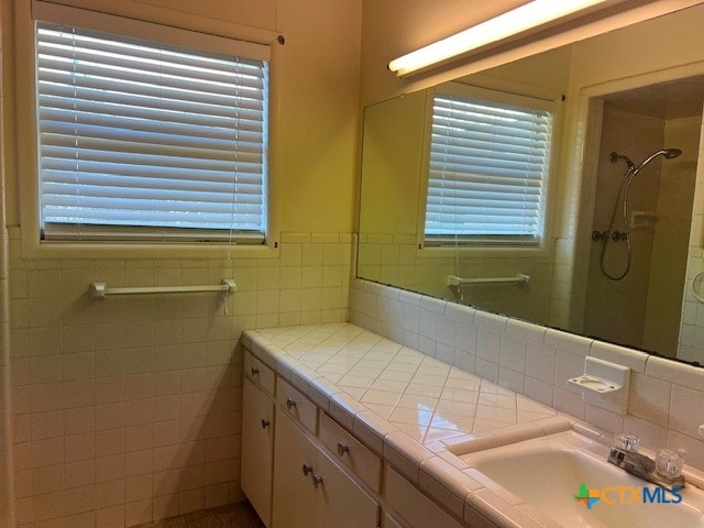 bathroom featuring vanity, tile walls, and a shower