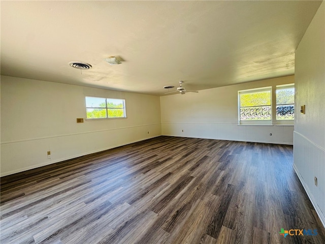 unfurnished room featuring dark wood-style flooring, visible vents, and ceiling fan