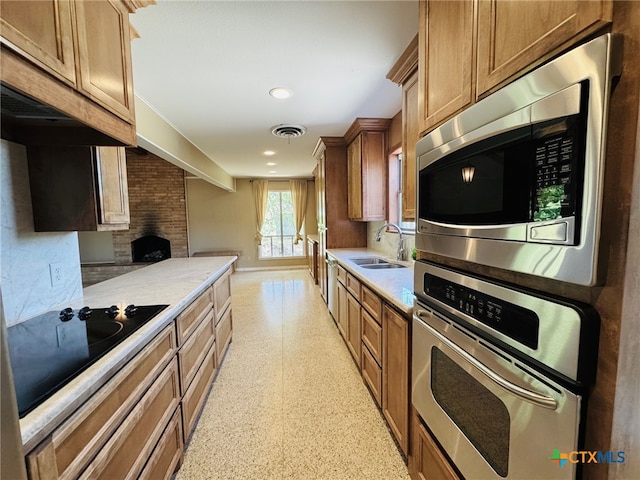 kitchen featuring visible vents, a sink, light countertops, appliances with stainless steel finishes, and brown cabinets