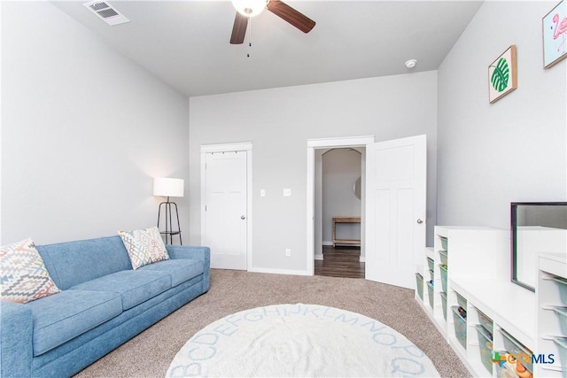 living room featuring baseboards, visible vents, ceiling fan, and carpet flooring