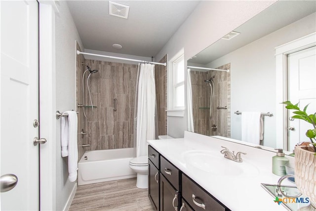 bathroom with toilet, shower / bath combo, vanity, and visible vents