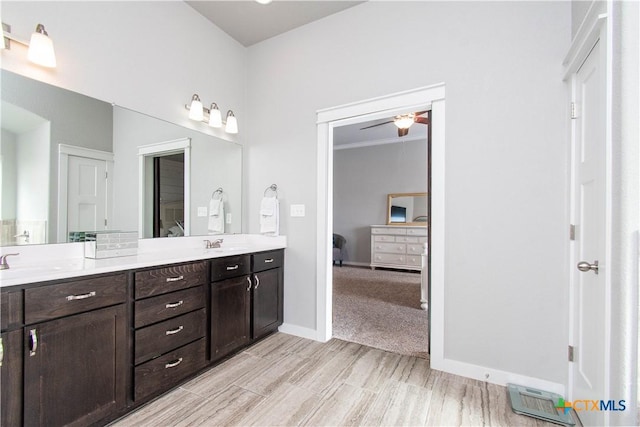 full bath featuring double vanity, ensuite bath, baseboards, and a sink