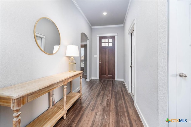 entrance foyer with baseboards, arched walkways, wood finished floors, and crown molding