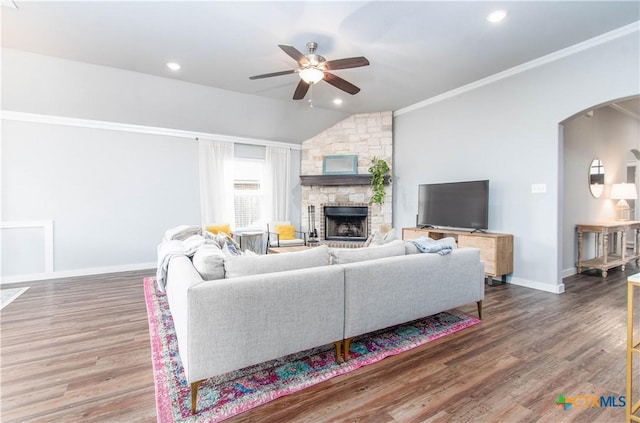 living room featuring arched walkways, ornamental molding, ceiling fan, wood finished floors, and baseboards