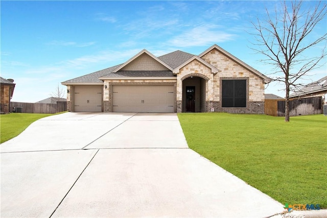 view of front of property featuring a shingled roof, concrete driveway, an attached garage, fence, and a front lawn