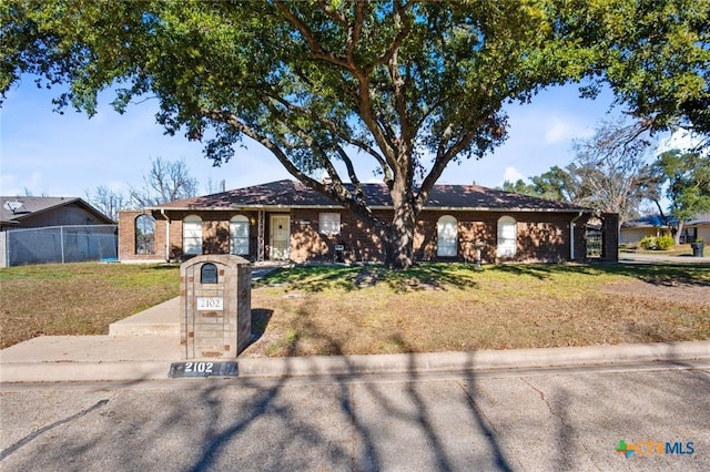 ranch-style home featuring a front lawn