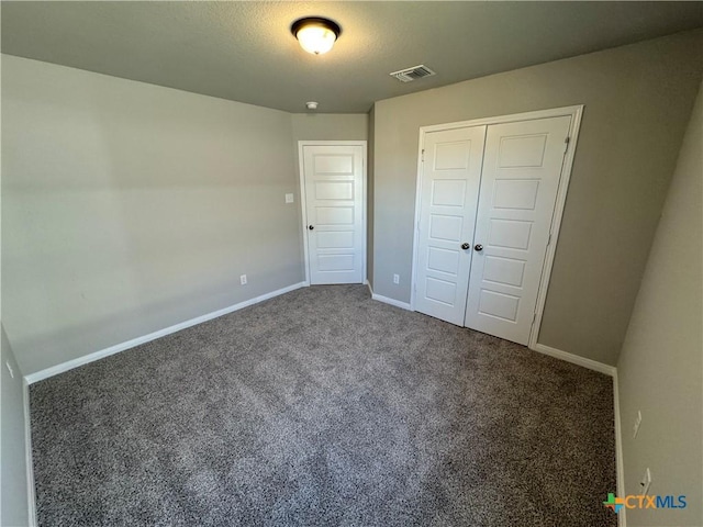 unfurnished bedroom featuring carpet floors, a closet, and a textured ceiling