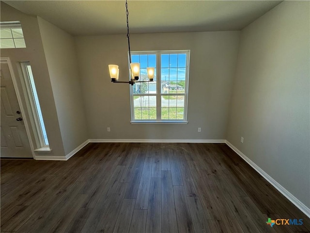 unfurnished dining area featuring dark wood-type flooring and a notable chandelier