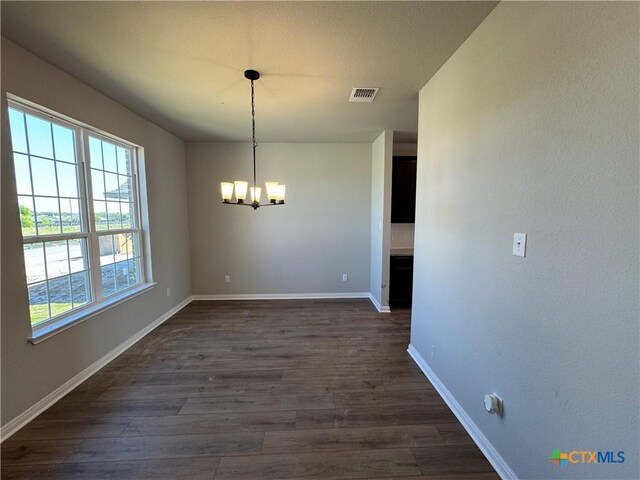 kitchen featuring concrete flooring, a textured ceiling, light stone countertops, sink, and a kitchen island with sink